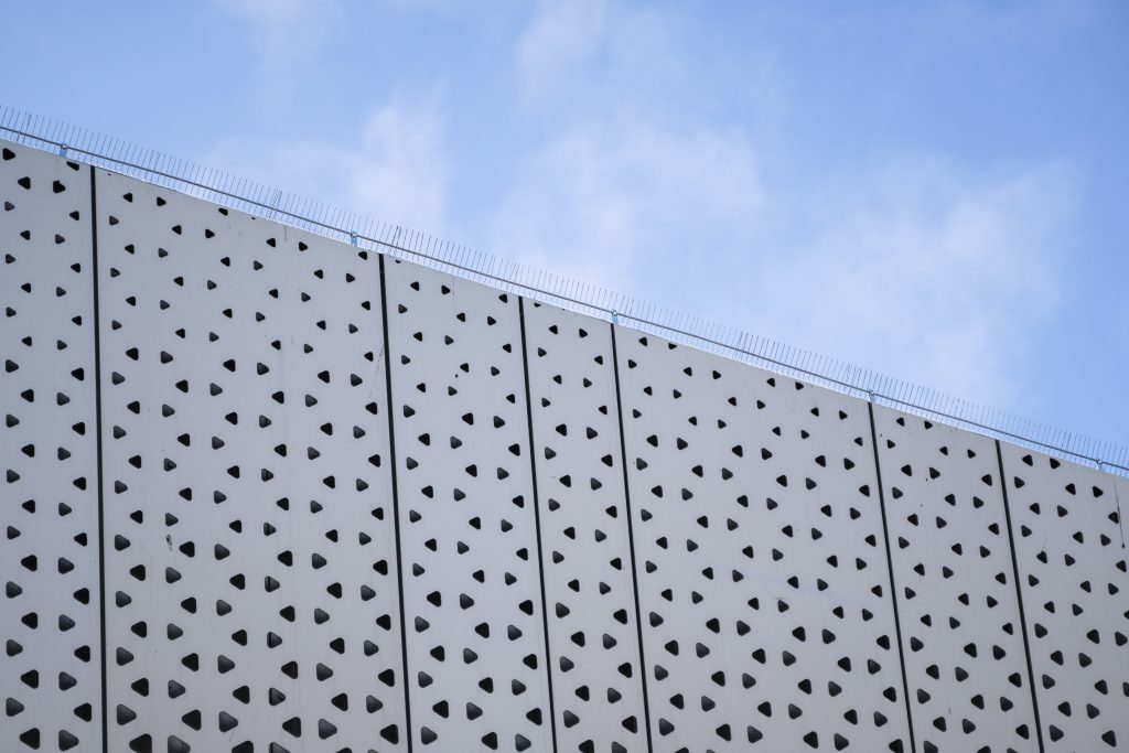 Architecture detail of a modern building with a blue sky on background. Facade design.
